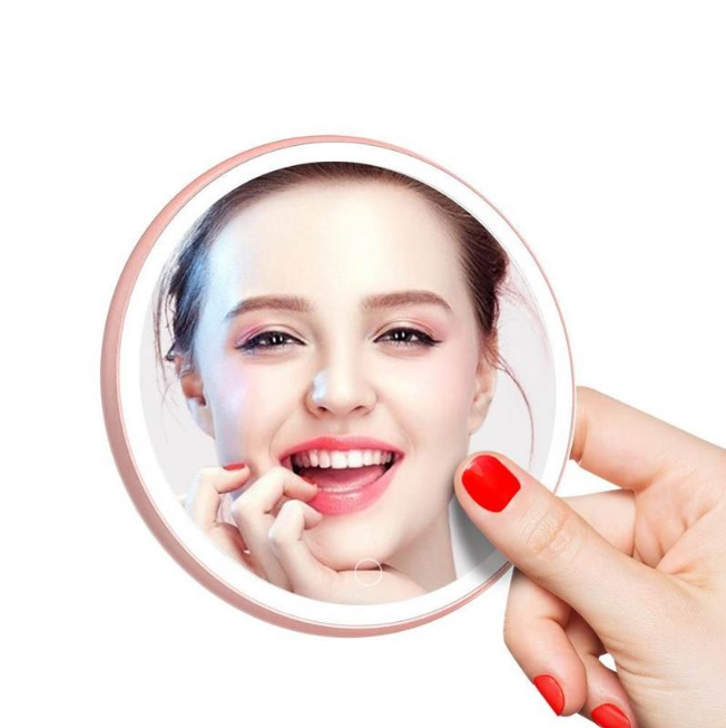 LED Portable Makeup Mirror with Built-in Wireless Charger - Rose Gold held by hand with bright makeup reflection