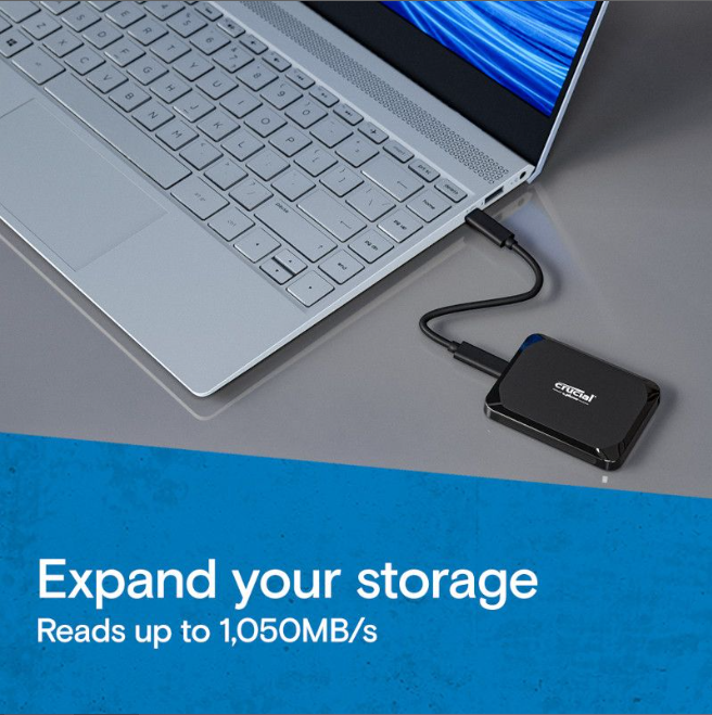 Crucial X10 2TB USB-C SSD – Reliable High-Speed Portable Drive connects to a laptop, offering up to 1,050MB/s read speeds.