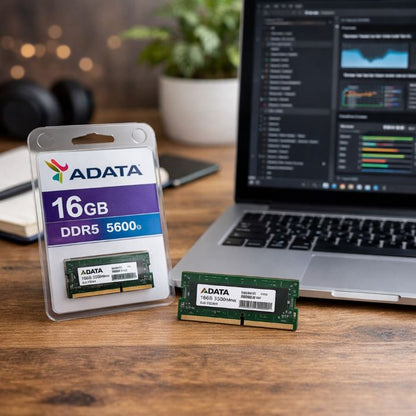 ADATA RAM module and packaging on a desk with a laptop in the background
