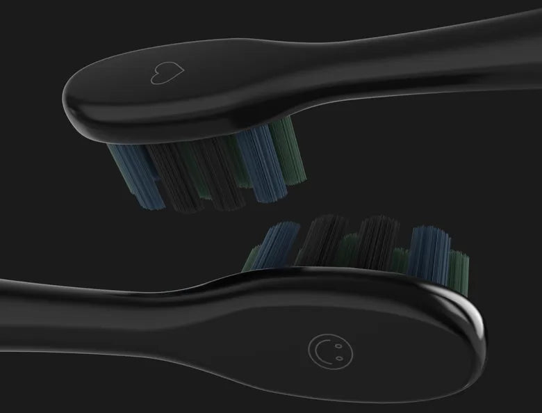 Two black toothbrushes for the Aeno DS2S Sonic Electric Toothbrush with blue bristles on a black background