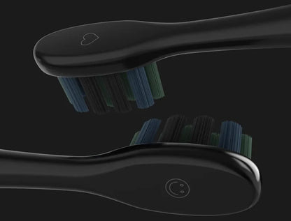 Two black toothbrushes for the Aeno DS2S Sonic Electric Toothbrush with blue bristles on a black background