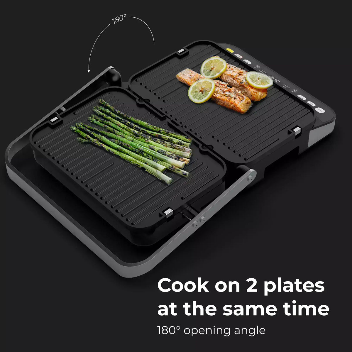 Portable grill with two plates for cooking salmon, asparagus, and lemon slices on a black background.