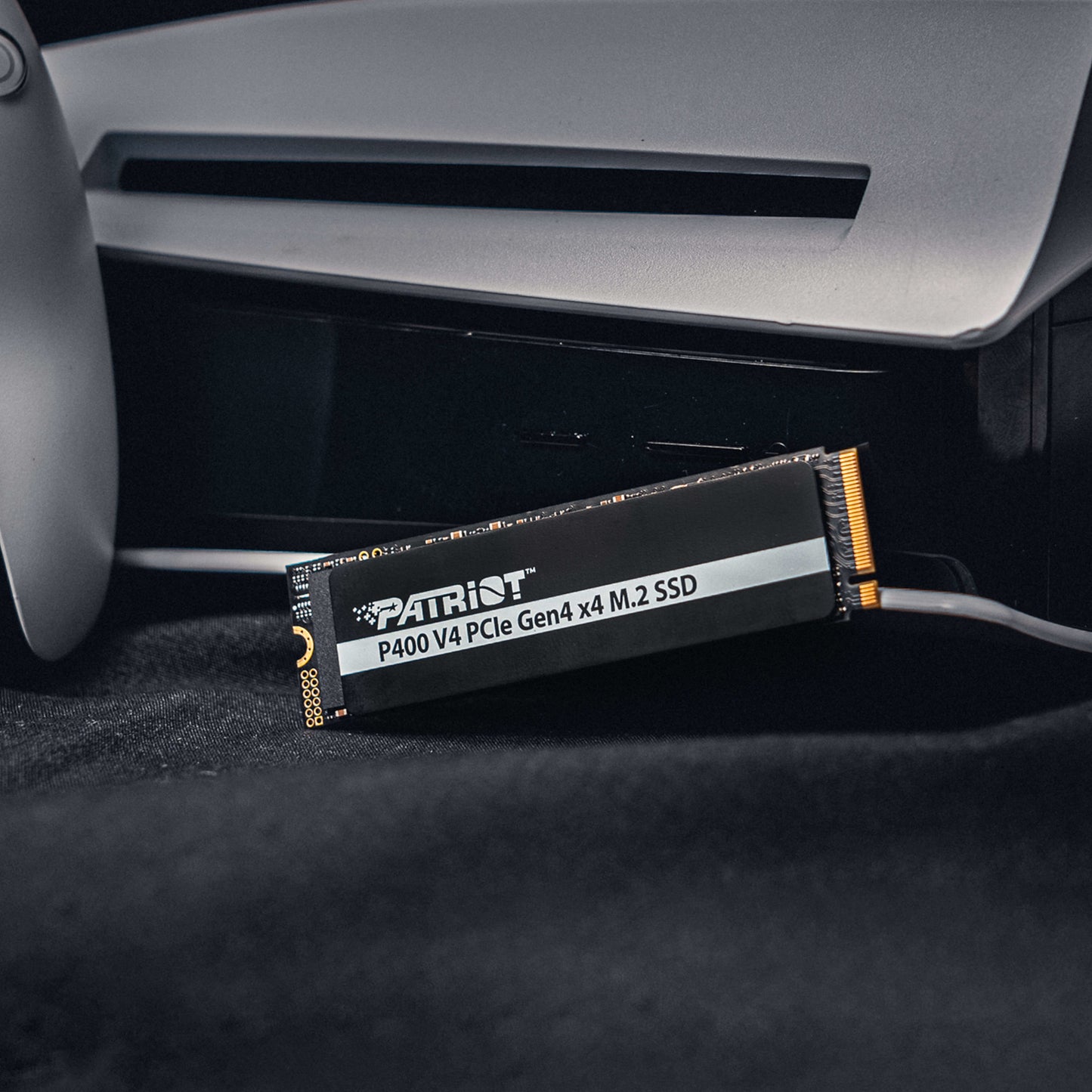 Patriot P400 V4 PCIe Gen4 x4 1TB M.2 2280 NVMe SSD installed next to a gaming console for ultra-fast storage.