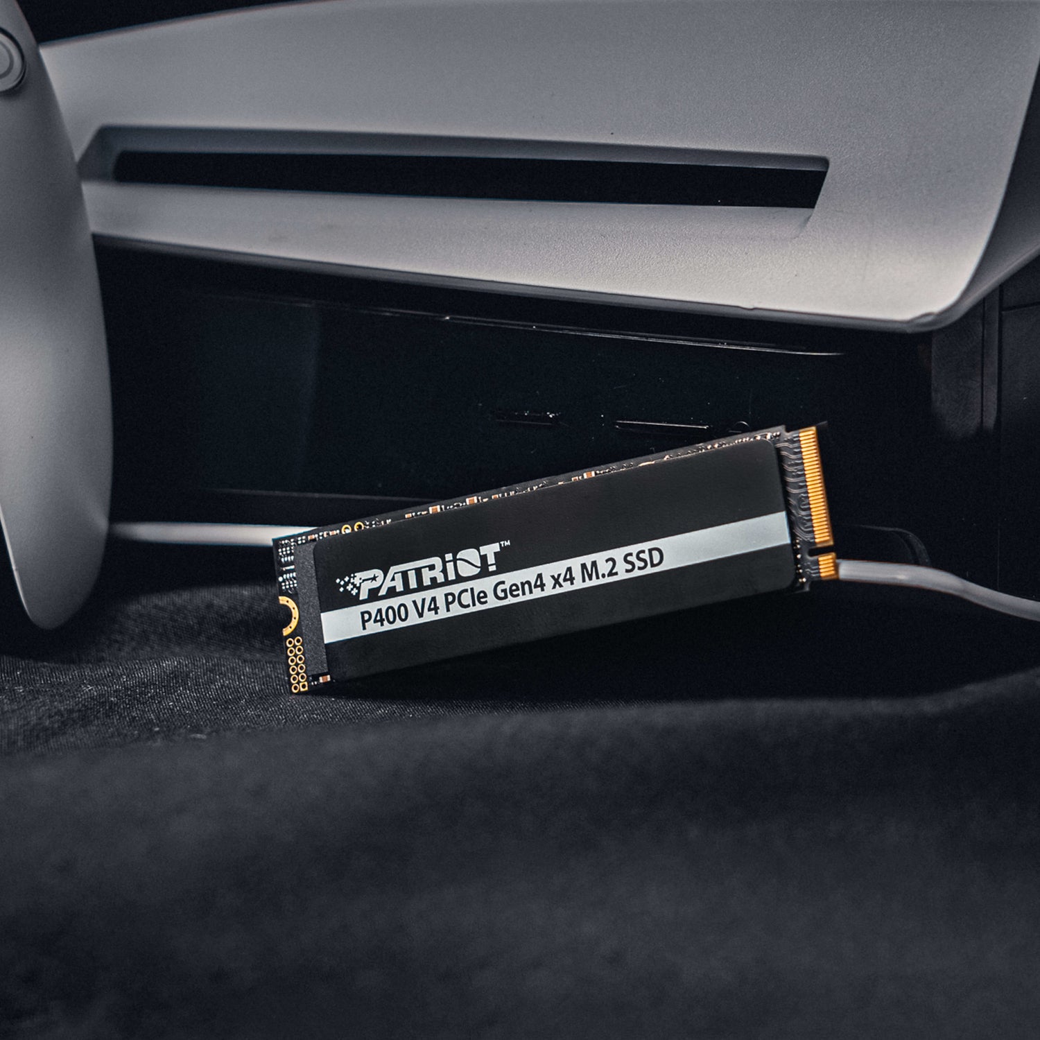 Patriot P400 V4 PCIe Gen4 x4 1TB M.2 2280 NVMe SSD installed next to a gaming console for ultra-fast storage.