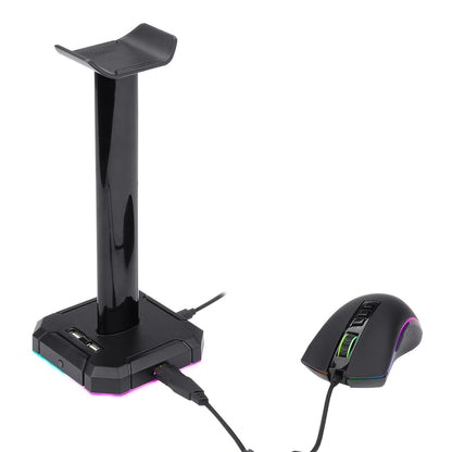 Redragon HA300 Scepter Pro RGB Headset Stand with USB Hub (4 x USB 2.0, RGB Lighting) on desktop with headset and glowing ambient lighting.
