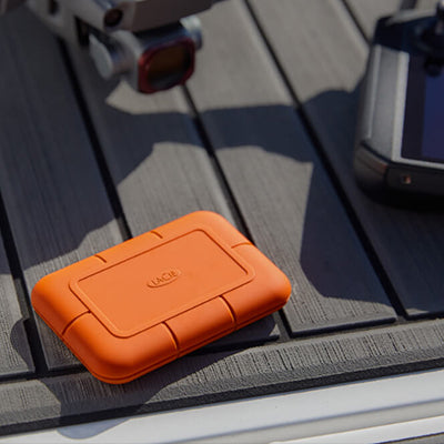 Orange LaCie hard drive on a car dashboard