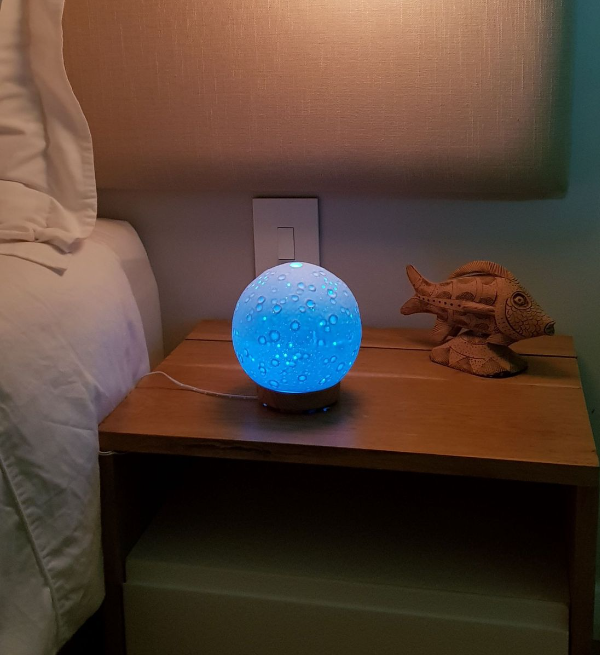 3D Moon Lamp Aromatherapy Diffuser with Wooden Base – Relaxing and Stylish Home Decor glowing softly on a bedside table.