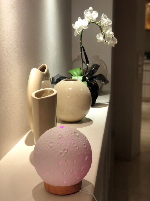 3D Moon Lamp Aromatherapy Diffuser with Wooden Base – Relaxing and Stylish Home Decor on shelf with elegant vases and orchid bloom