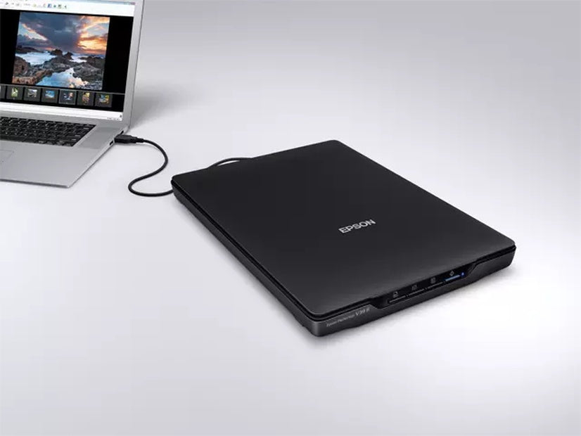 Epson Perfection V39II Photo and document scanner connected to a laptop, showcasing its sleek design and functionality.