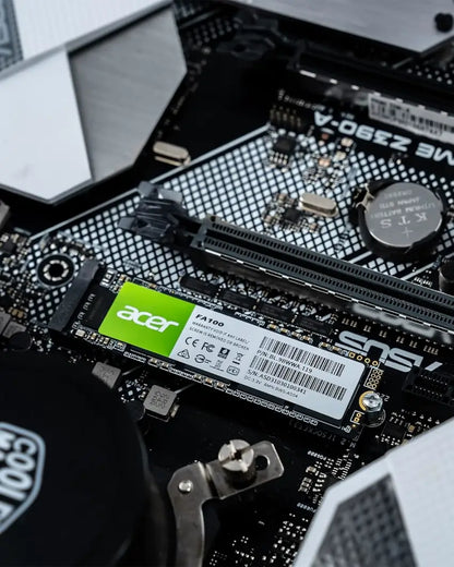 Close-up of a computer motherboard with an Acer FA100 NVME M.2 solid-state drive installed.