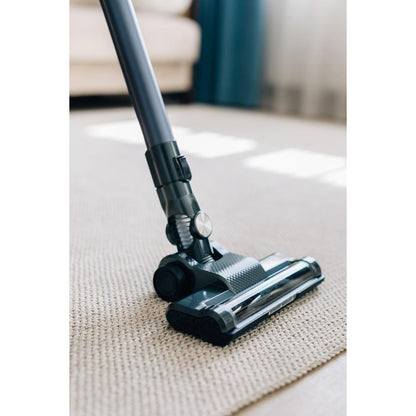 AENO Cordless vacuum cleaner SC1 with LED lighted brush, displayed on a carpeted floor, indicating its use for cleaning and maneuverability.